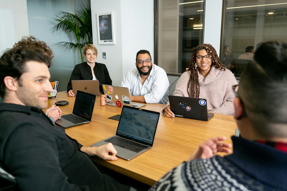 A team at a meeting table with their laptops